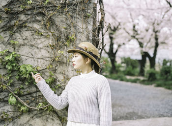 Woman looking at ivy leaves on wall