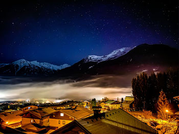 Illuminated buildings against sky at night