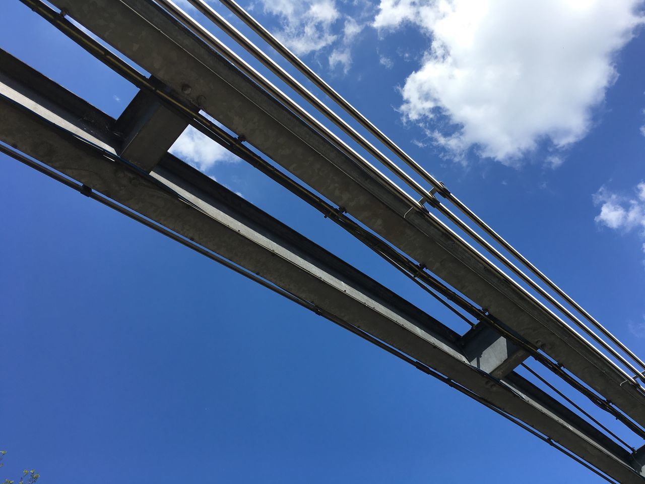 low angle view, sky, built structure, architecture, connection, blue, day, outdoors, bridge - man made structure, cloud - sky, no people, building exterior, girder