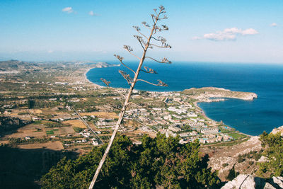 Aerial view of sea and mountains against blue sky