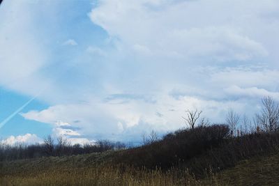 Scenic view of field against cloudy sky