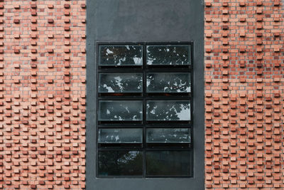 Dark window flanked by two brick walls