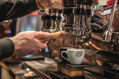 Cropped image of barista making coffee at cafe