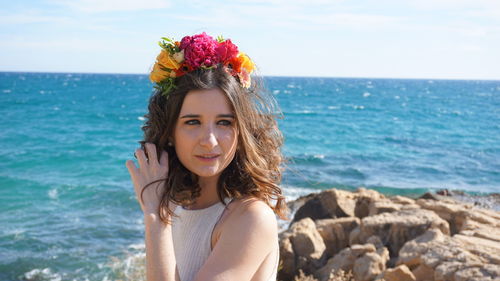 Portrait of beautiful woman by sea against sky