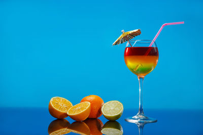 Low angle view of drink on table against blue sky