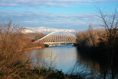 View of bridge over river against cloudy sky