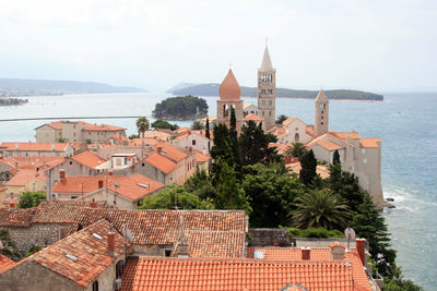 High angle view of townscape by sea against sky