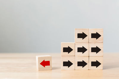 Wooden block with red arrow facing the opposite black arrow