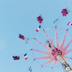 Low angle view of ferris wheel against clear blue sky