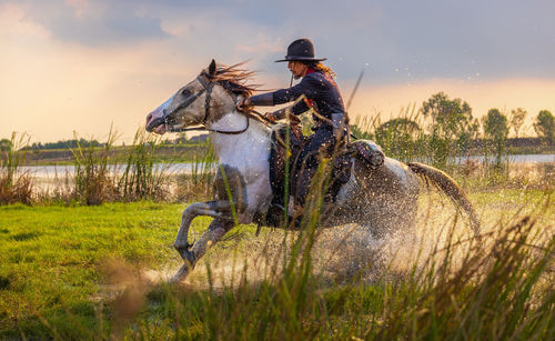 Cowboys riding horses beside the river and lifestyle with natural light background.