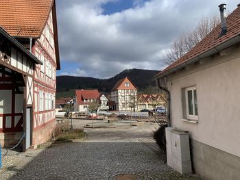 Houses by street in typical german town against sky