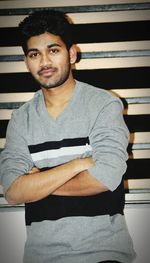 Portrait of young man standing against wall