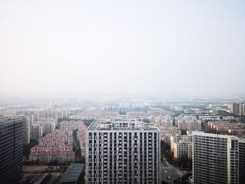 High angle view of modern buildings in city against clear sky