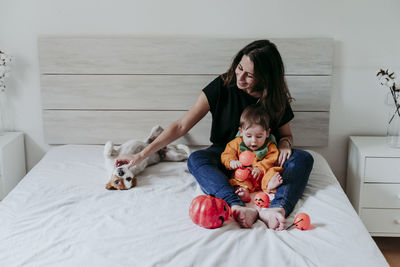 Full length of mother and daughter on bed