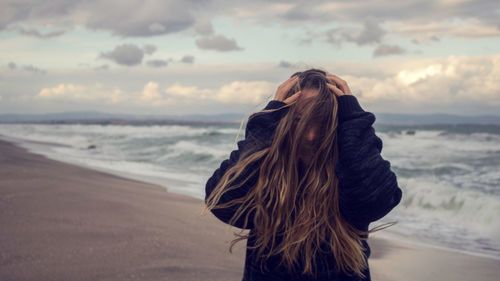 Teenage girl with tousled hair against sea at beach