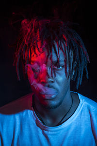 Portraits of beautiful african young man under blu and red lights