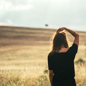 Rear view of woman standing on field