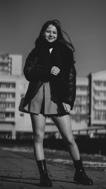 Portrait of young woman standing on street