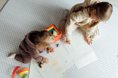 High angle view of girl playing with teddy bear