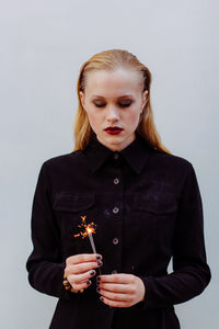 Portrait of young woman holding sparkler