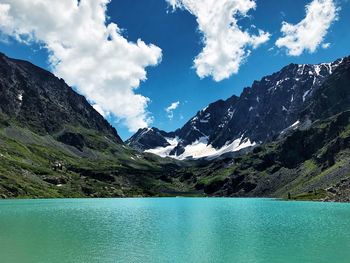 Scenic view of lake by mountains against sky