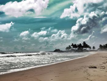 Scenic view of beach against cloudy sky