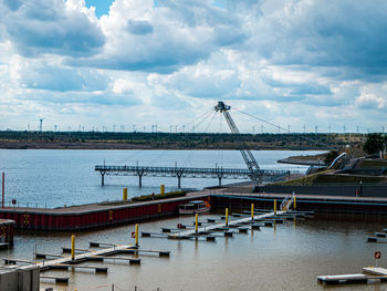 Sailboats moored at harbor against sky