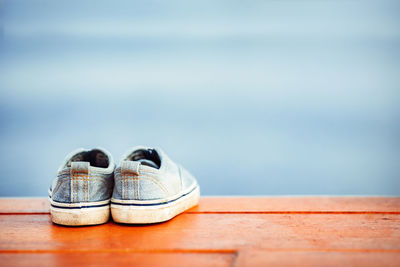 Close-up of shoes on wooden table