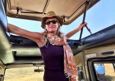 Mature woman standing in safari vehicle