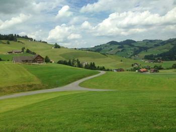 Scenic view of grassy field against cloudy sky