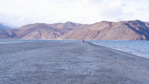 Scenic view of sea and mountains against sky