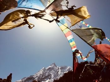 Low angle view of flags against clear sky during sunny day