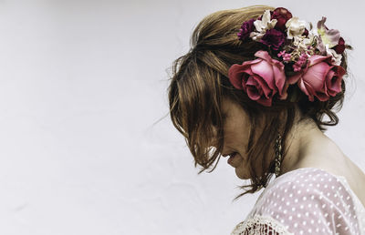 Woman wearing flowers against white background