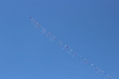 Low angle view of vapor trail against clear blue sky