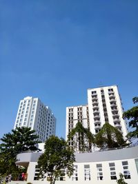 Low angle view of skyscrapers against clear blue sky
