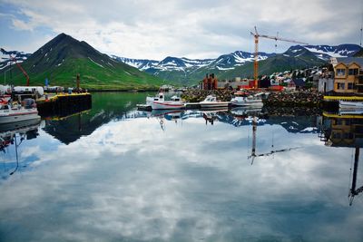 Boats moored at harbor with mountain in background