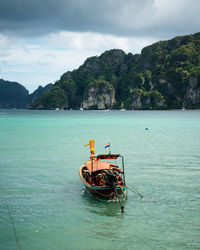 Fishing boat in sea against sky