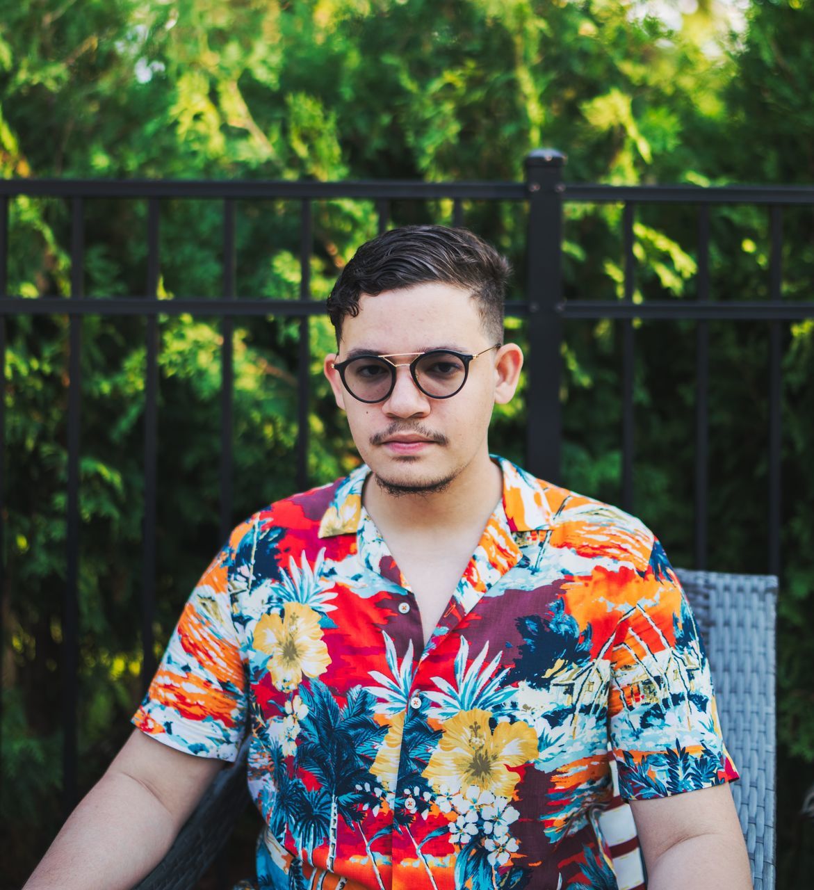 front view, one person, portrait, real people, glasses, young adult, leisure activity, lifestyles, young men, casual clothing, looking at camera, standing, fashion, focus on foreground, waist up, day, pattern, plant, outdoors, floral pattern