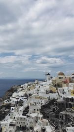 High angle view of townscape by sea against sky