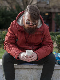Midsection of man holding coffee cup
