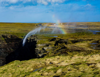 Scenic view of waterfall against sky