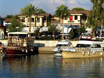 Boats moored in river against buildings