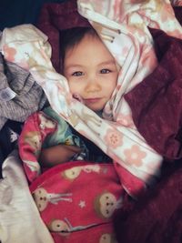High angle portrait of cute baby girl lying on bed at home