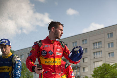 Young man looking away against sky