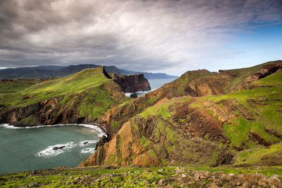 Scenic view of mountains and sea against cloudy sky