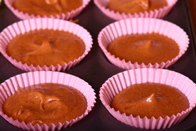 High angle view of cake batter in cupcake holder at table