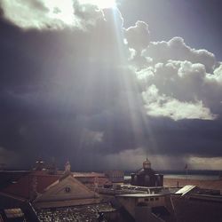 Silhouette of buildings against cloudy sky