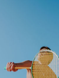 Low angle view of woman against blue sky