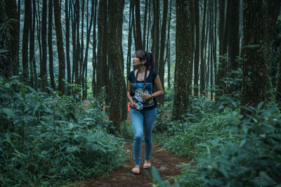 Full length of asian woman walking in forest