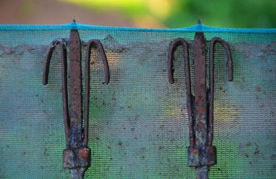 Close-up of rusty metal hanging on wood